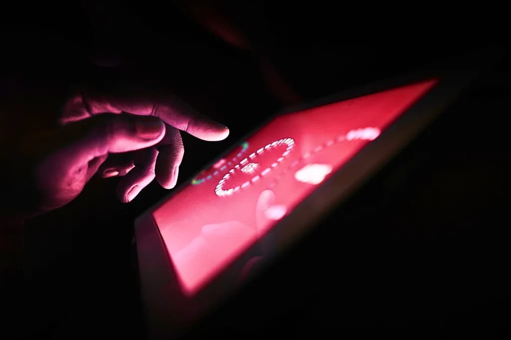 Hand interacting with a red-lit control surface